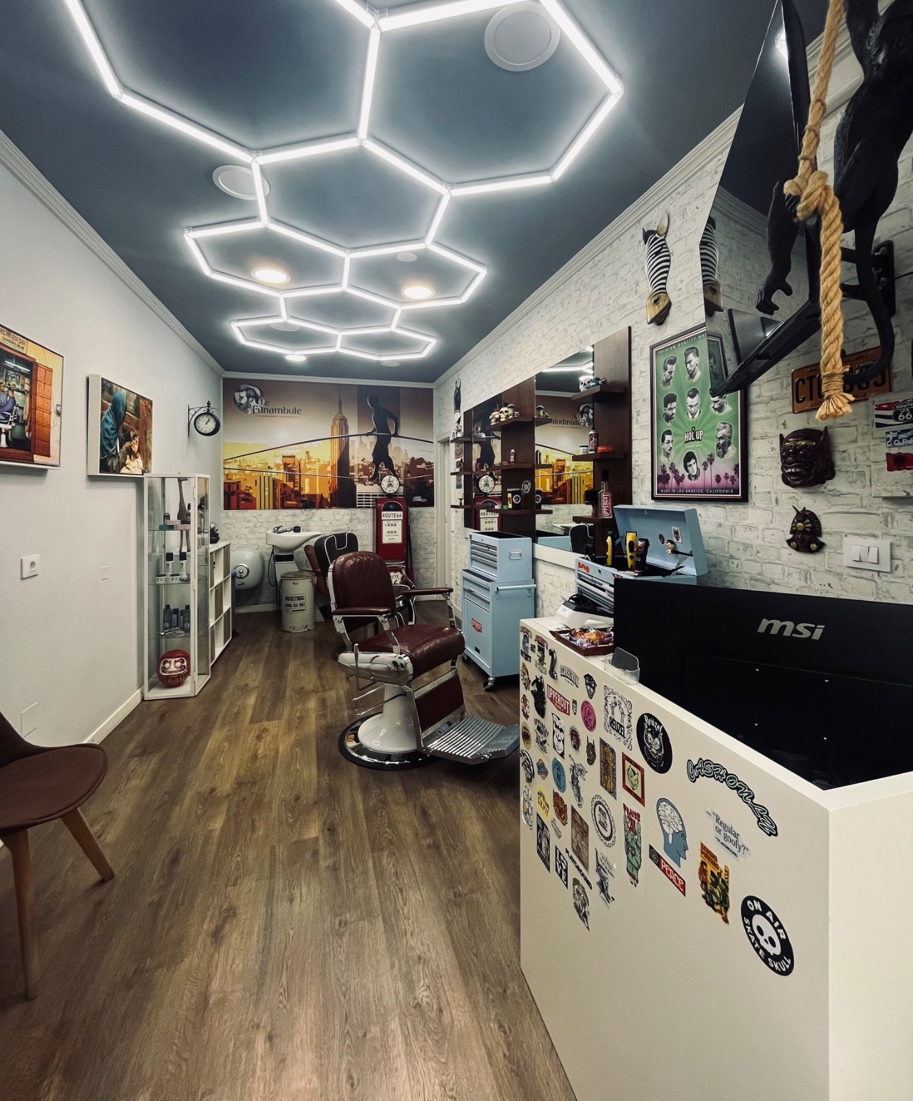 El local de Sergio Piñeiro Hair Studio en Rúa Bastida, Pontevedra: techo de luces hexagonales, ladrillo blanco y sillón de barbero